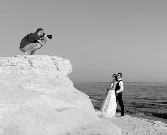 fotografo in azione al mare con due sposi