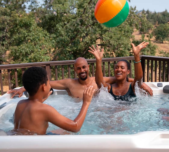 a man and woman playing with a beach ball in the water