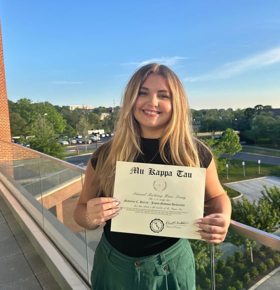 A young woman holding a certificate