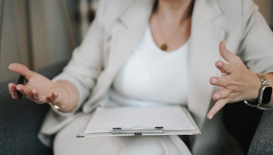 a woman in a white suit and a notebook with a pen and a pen