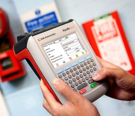 a person holding a portable appliance tester