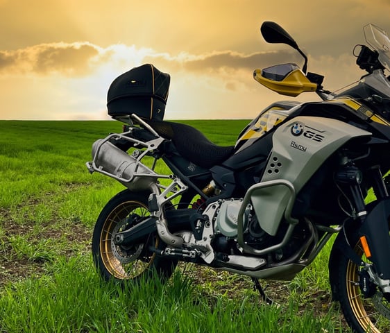 Remy Luxury Helmet Bag resting on a motorcycle seat with the sun setting in the background,