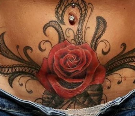 tattoo of a red rose on a womens lower abdomen