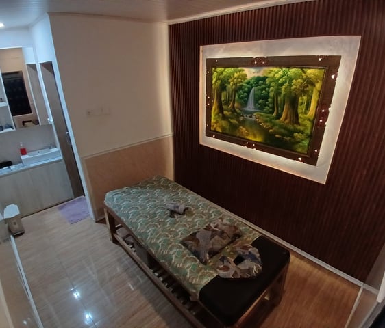a bed with a bench and a painting on the wall
