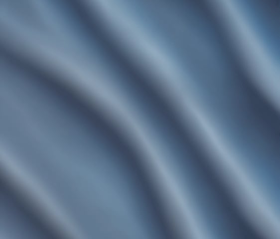 A laptop resting on a wooden table displays a graphic design software with a black card featuring a letter 'C' and a QR code. The background reveals a modern cafe setting with cushioned chairs, wooden tables, and soft lighting, all contributing to a cozy atmosphere.