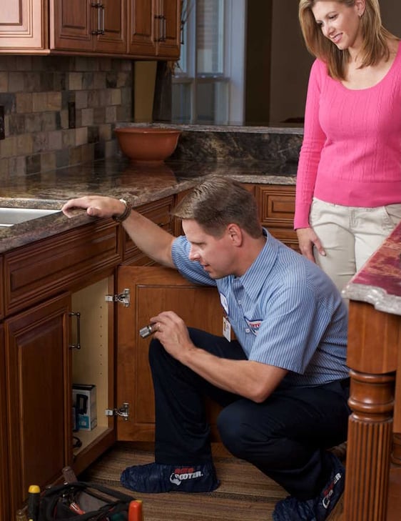 Roto-Rooter Plumbing Technician Showing Client Plumbing Issue