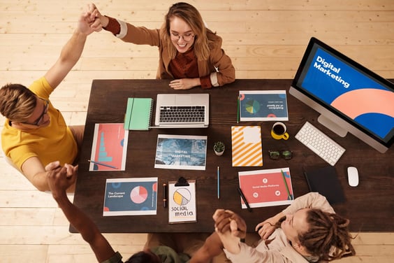a group of people sitting at a table with laptops