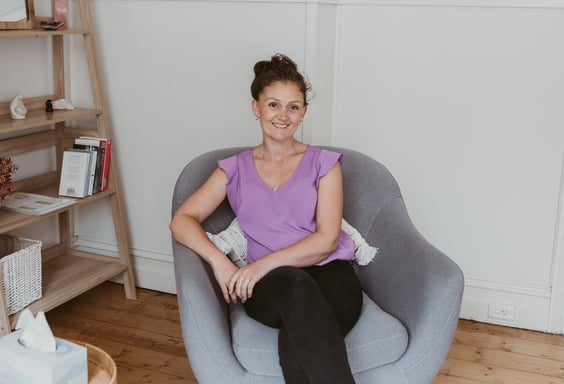 a woman sitting in a chair with a bookcase