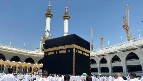 Vur de la kaaba au centre de la mosquée Al Haram à la Mecque, entourée de pèlerins en tenu d'ihram.