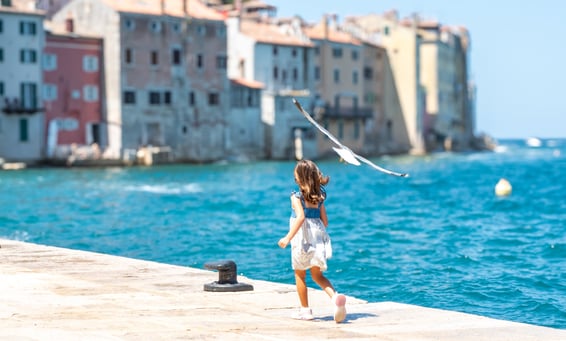 A young girl chasing a seagull along to coast of the Adriatic Sea