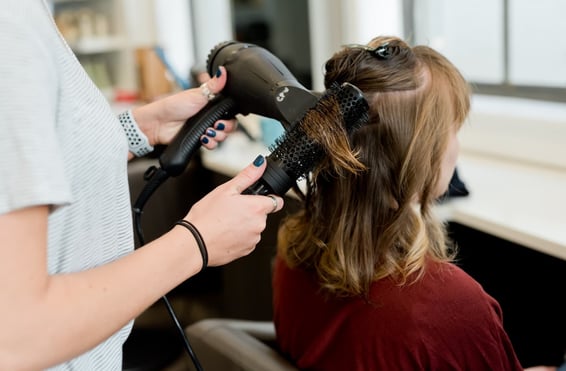 une femme se sèche les cheveux dans un salon