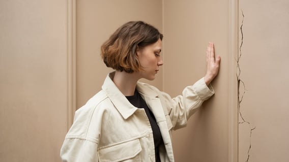 Une femme fait face à un mur, elle souhaite le dépasser et doit faire preuve de persévérance.