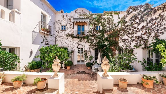 Rustic Spanish villa for rent featuring a charming ivy-covered patio
