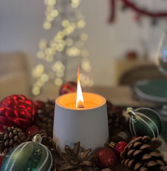 Une bougie authentique, en plâtre blanc en combustion avec des décorations de noël 