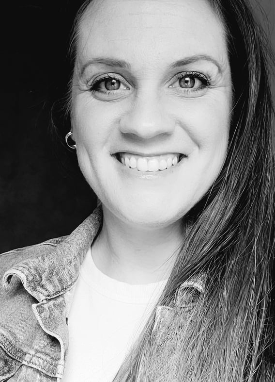 black and white photo of a woman's face with her hair down to one side and smiling