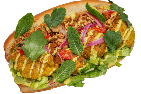 a sandwich bun with roasted coronation cauliflower, pickled red onions, lettuce and herbs
