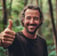 a man with a beard and a beard smiles while holding a banana peel