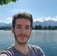 a man with a beard and a beard, standing in front of a lake