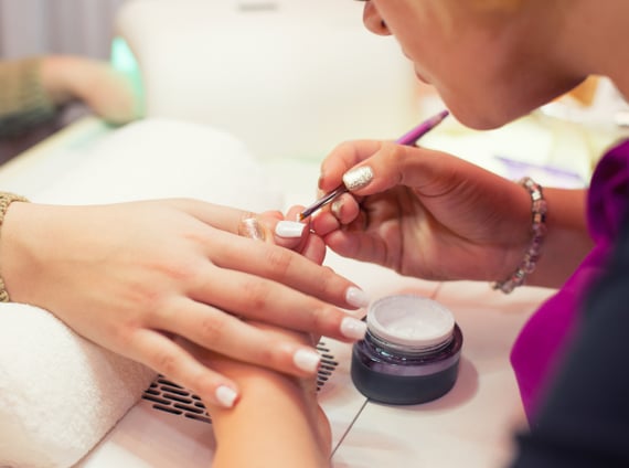 A lady receiving a nail treatment from a meticulous manicurist