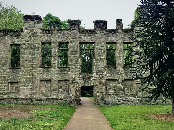 a large historical stone building with a walkway