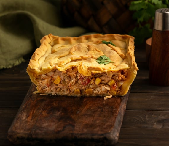 Fatia de torta de frango cremosa com recheio suculento e massa dourada