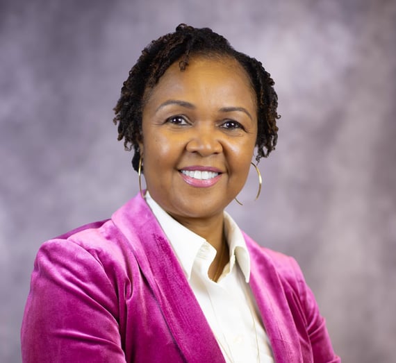 headshot of East Texas Custom Home builder Tracy Dews in magenta blazer and white shirt