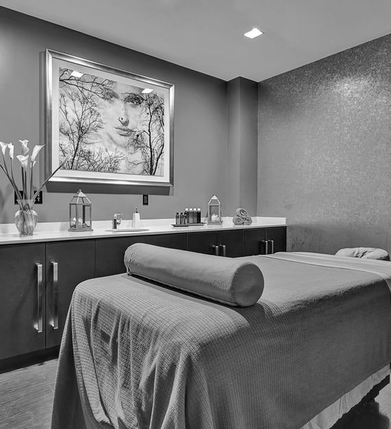 a massage room with a massage table and a large painting