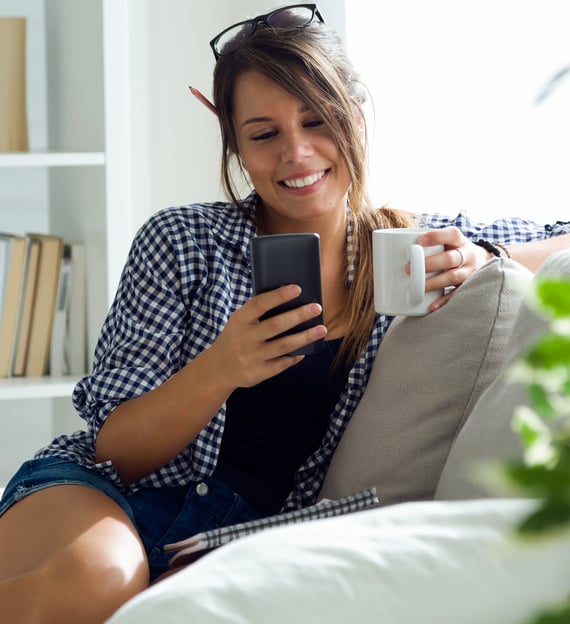 a woman sitting on a couch with a cup of coffee