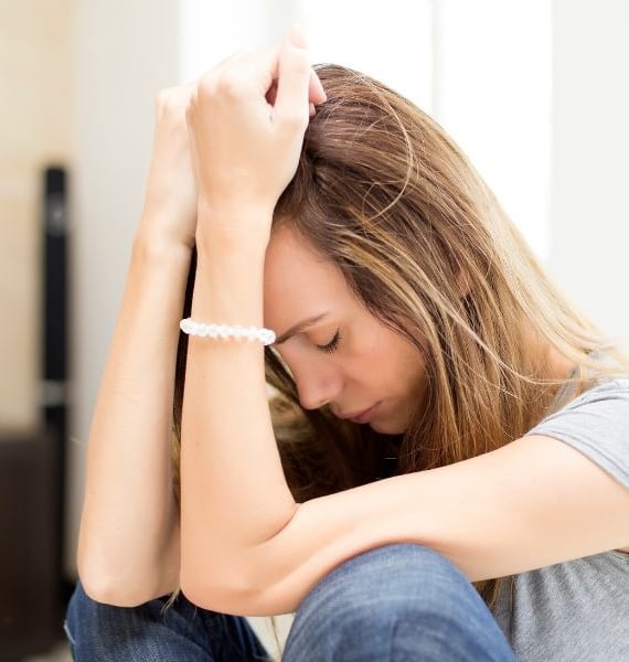 a woman sitting on a couch with a bracelet