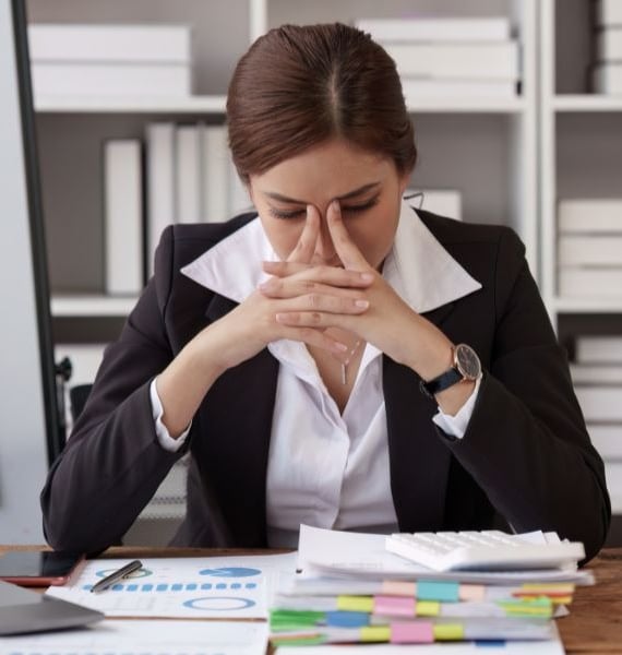 a woman in a business suit sitting at a desk