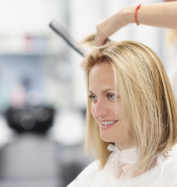 a woman is getting her hair cut by a hairdressuck