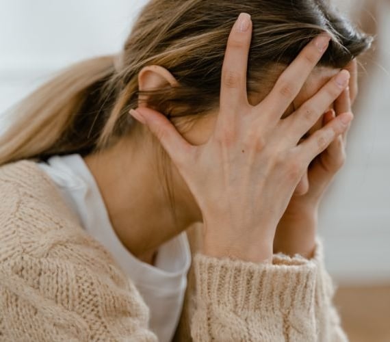 a woman with her hands on her face