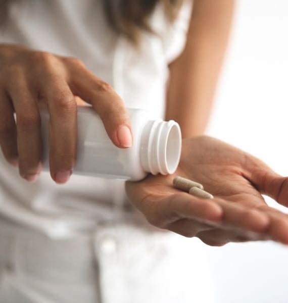 a woman holding a pill bottle