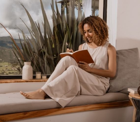 a woman sitting on a couch reading a book