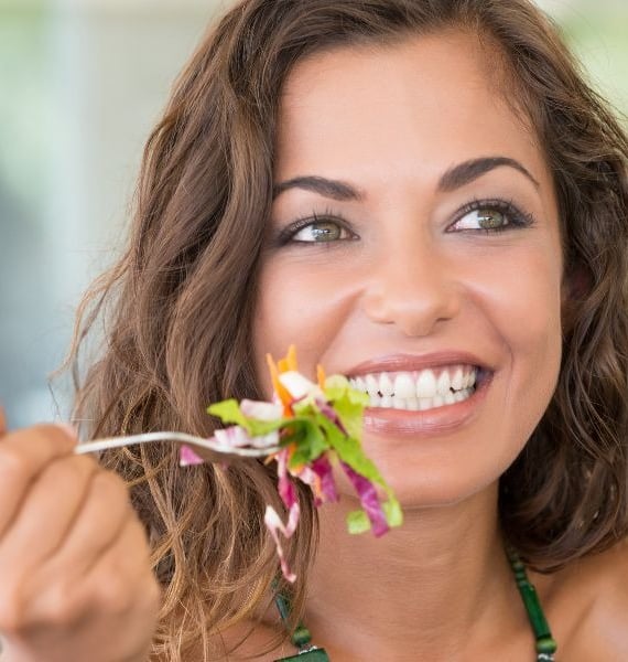 a woman eating a salad with a fork