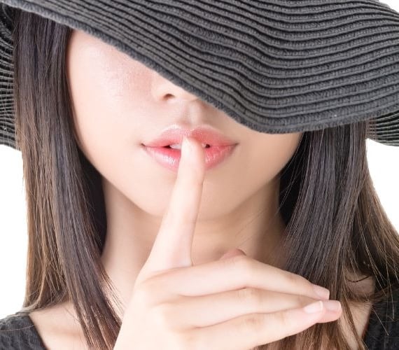 woman with a finger to her mouth
