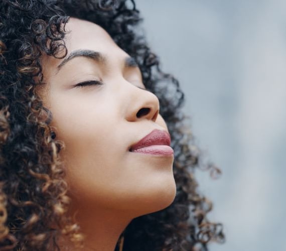 woman with eyes closed breathing air