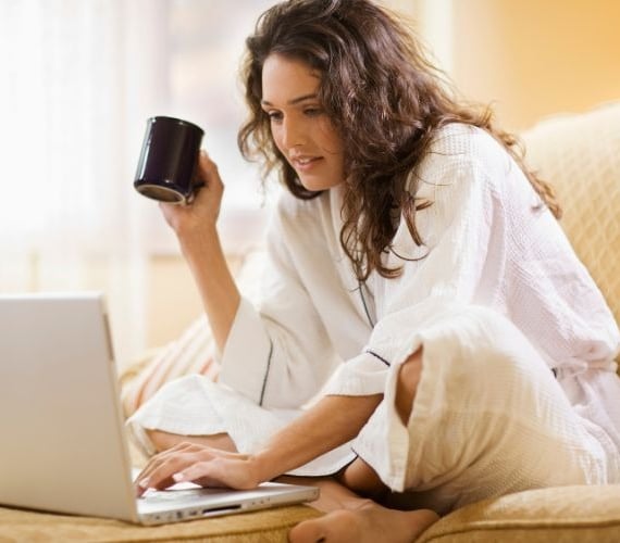 a woman sitting on a couch with a cup of coffee