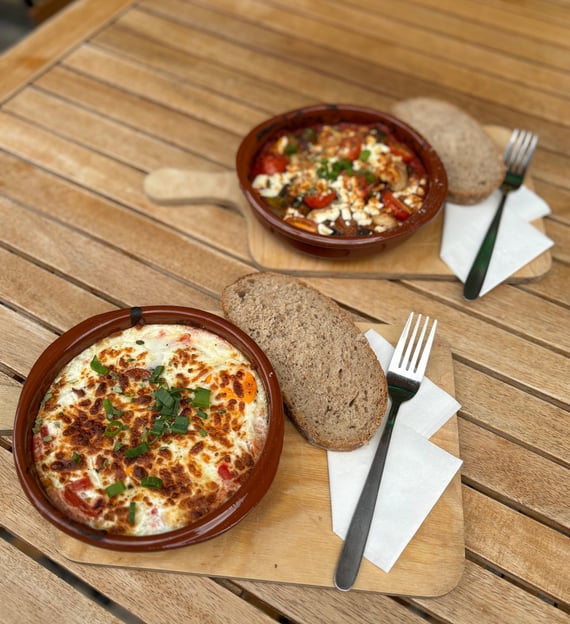 a bowl of food on a table with bread