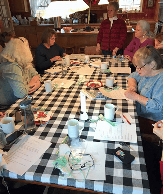 a group of ladies sitting around a table sewing