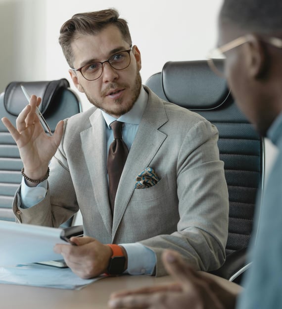 a man in a suit and tie is sitting at a table