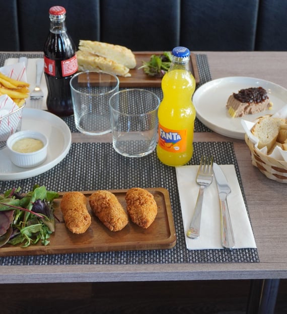 Table setting with a variety of foods including crispy breaded croquettes with salad, golden French