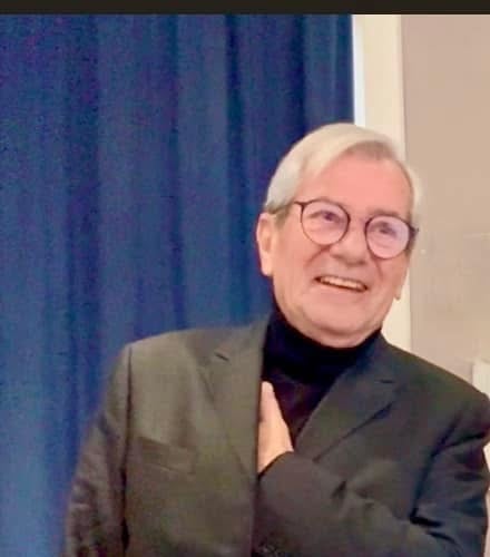 a man in a suit and glasses smiling