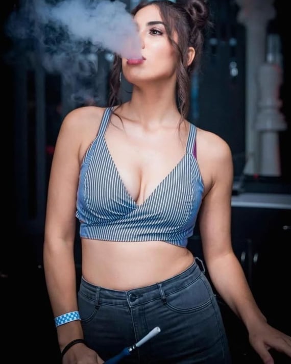 a woman smoking a cigarette in a barbeque