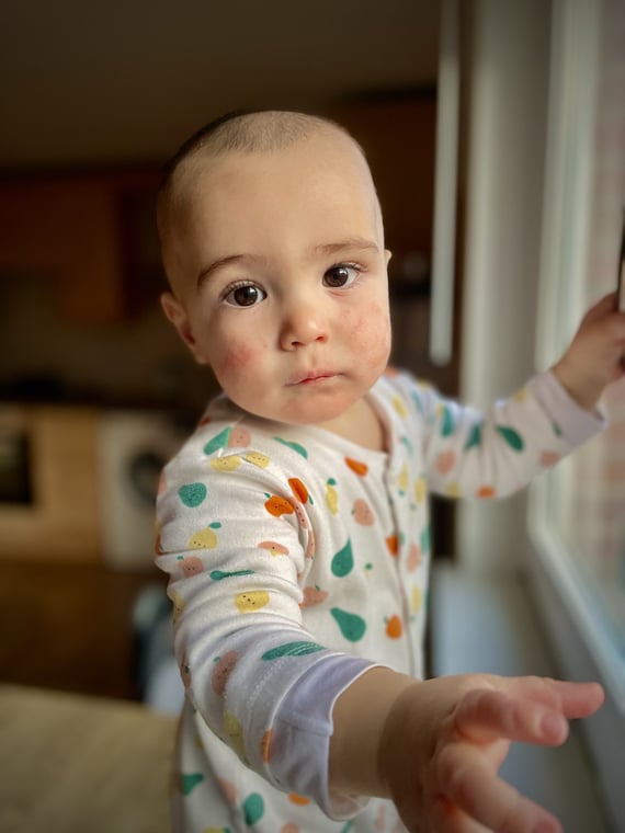 a baby is standing in front of a window