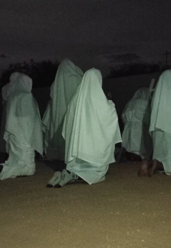 Penitentes encapuzados caminhando à noite, em ritual de fé na comunidade quilombola de São Tomé