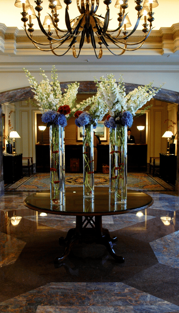 a table with vases and flowers in a hotel lobby