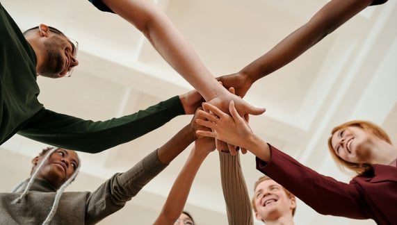 A team placing their hands on each other's hands