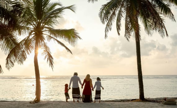 a father, mother and their two children on a seashore