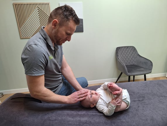 een man geeft een behandeling aan de schedel van een baby